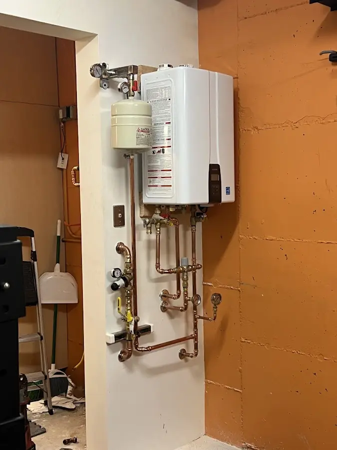 Plumbing technician inspecting water heater connections in Nottingham